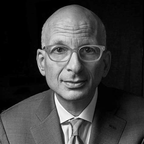 Black & white headshot of Seth Godin wearing tie, suit & glasses